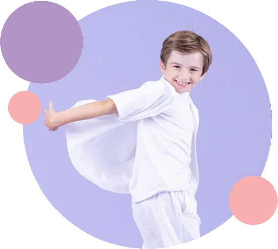 Young smiling boy dancer executing a movement in white attire